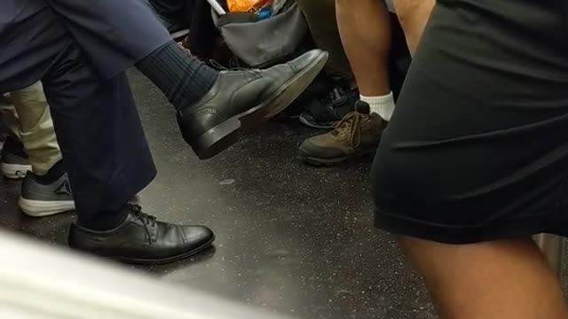 Woman on phone eating cheetos with white gloves subway