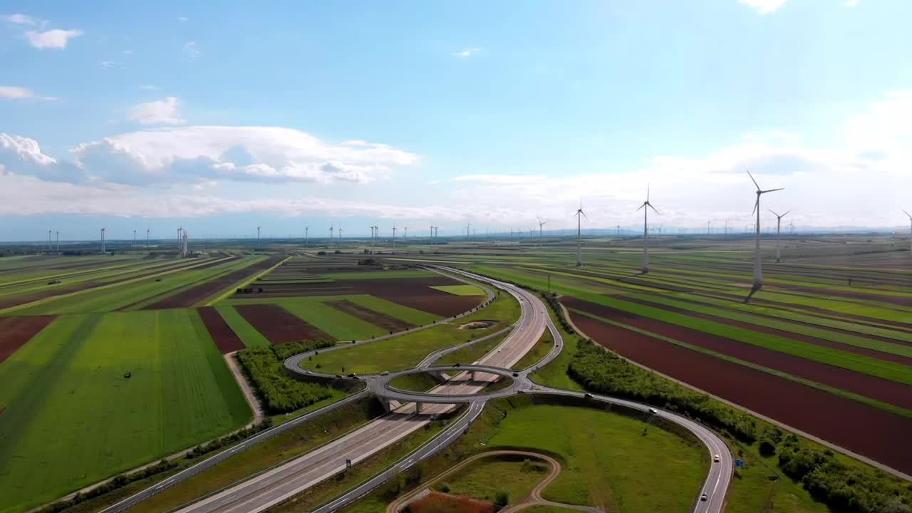 Highway traffic and a wind farm in the countryside