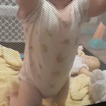 Baby Girl Makes Hilarious Faces On The Net Of Her Playpen