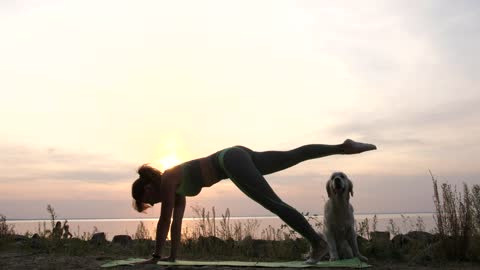 Woman exercising as the sun goes down