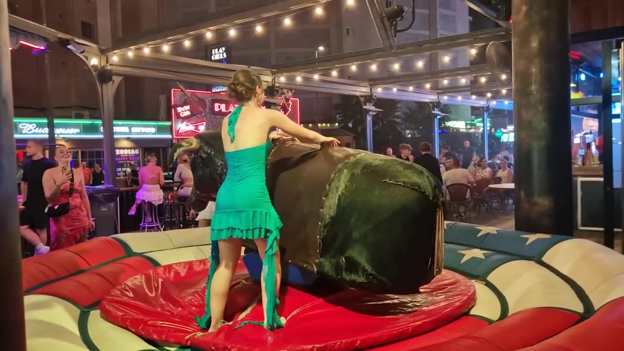 Pretty Girl in Blue Dress Riding on a Bull in Benidorm _ Mechanical Bull 4K.