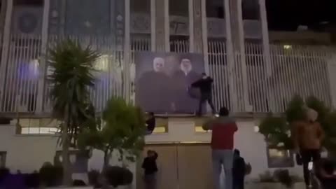 Protestors tearing down of posters of Qassem Soleimani and Hassan Nasrallah