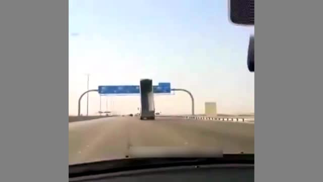 Careless dump truck driver hitting a huge road sign on the highway