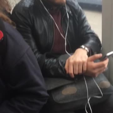 Close up of guy with white headphones on sitting on subway