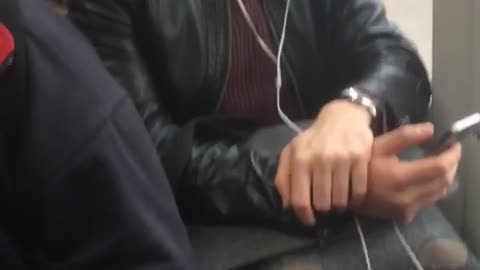 Close up of guy with white headphones on sitting on subway