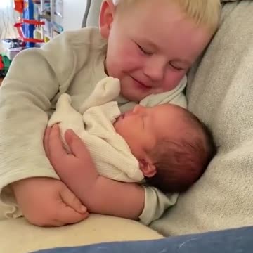 An older brother holds his baby sister for the first time. Tears flow...
