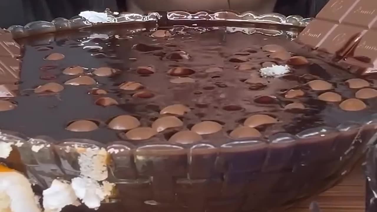 A TUB OF HOT CHOCOLATE WITH CHOCOLATE EGGS, CHOCOLATE BARS, CHOCOLATE WAFFLE, CHOCOLATE CAKES,EATING