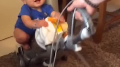 cute baby on top of the vacuum cleaner