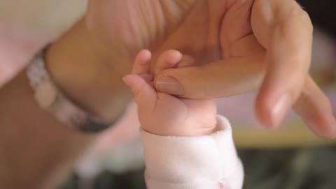 Mother holding hands with her baby