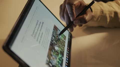 Hand of a man browsing the internet on a tablet