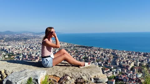 Cute Spanish girl watching Barcelona city from the hill