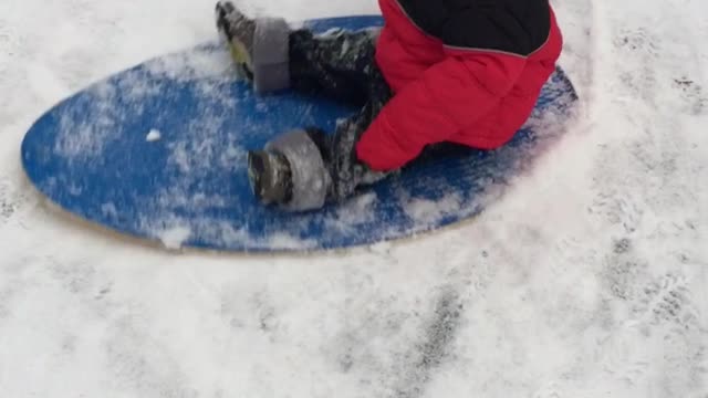 Baby flies down the hill on the snow