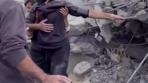 A Palestinian man amidst the rubble of his house searching for his family