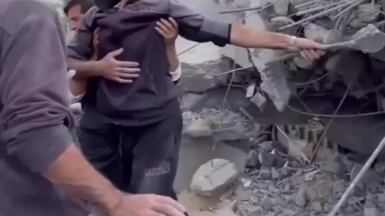 A Palestinian man amidst the rubble of his house searching for his family