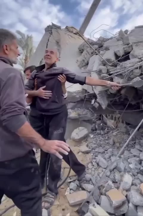 A Palestinian man amidst the rubble of his house searching for his family