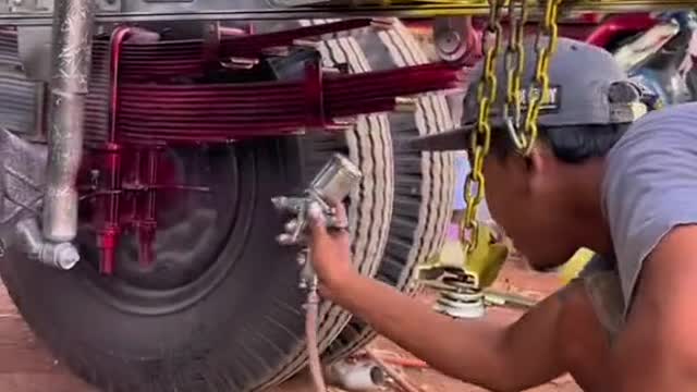 The repair man painted the surface of the big truck