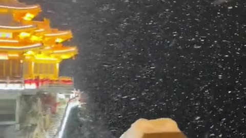 An entry view of a Chinese temple in the mountains during a storm