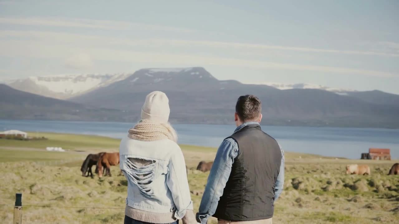 Back view of young tourists couple standing on the Iceland