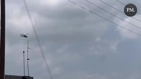 A government helicopter circles as a large group of Haitians who are awaiting the end of Title 42