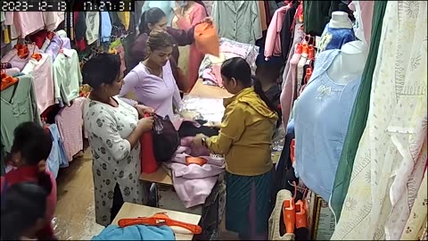 A woman carrying a blue-collared bag in the shop steals a white-collared suit