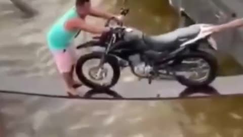 Pull the motorcycle across the wooden bridge and fall into the water halfway