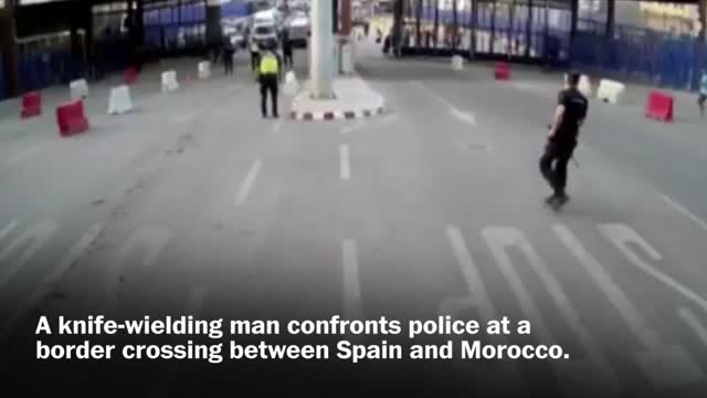 Spanish police throw traffic barrier at knife-wielding man