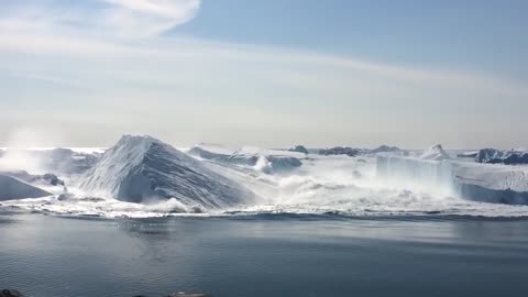 Ilulissat Icefjord - Large iceberg breaking over