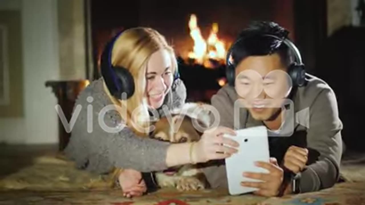 Young Couple Enjoys Tablet Lie Near Fireplace