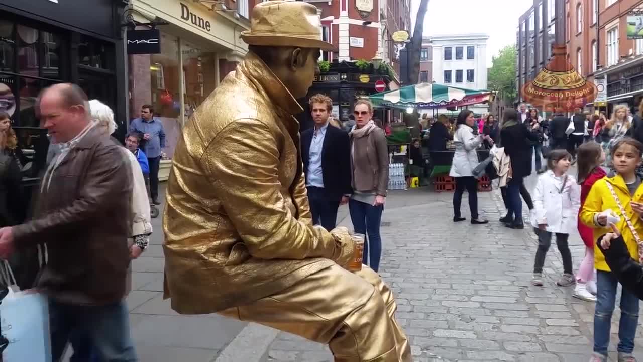 Golden man London street performer, floating and levitating trick Covent Gardens