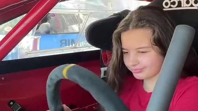 Super race car driver girl prepares to repair steering wheel before race.