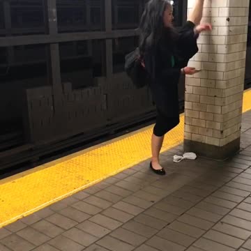 Girl does splits on wall on subway platform
