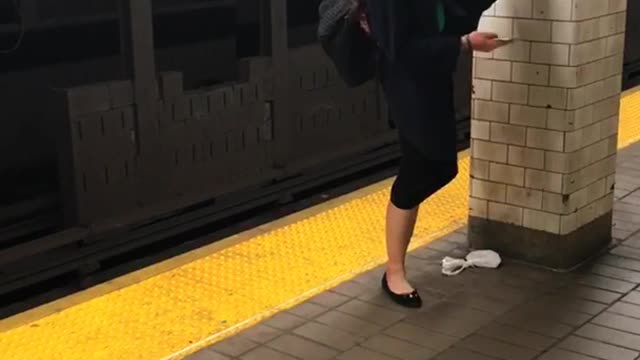 Girl does splits on wall on subway platform
