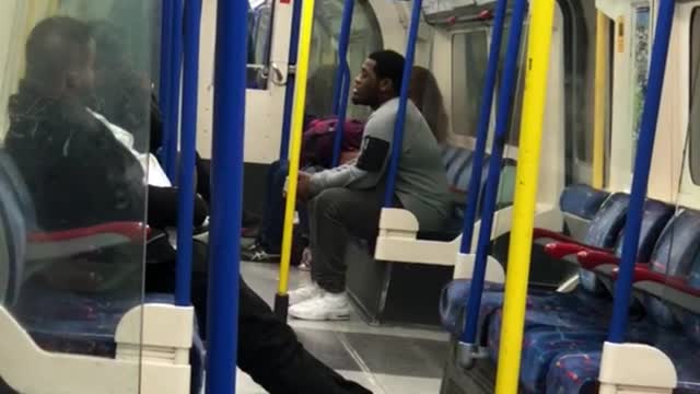 Man on subway with stretched legs knocks off boots