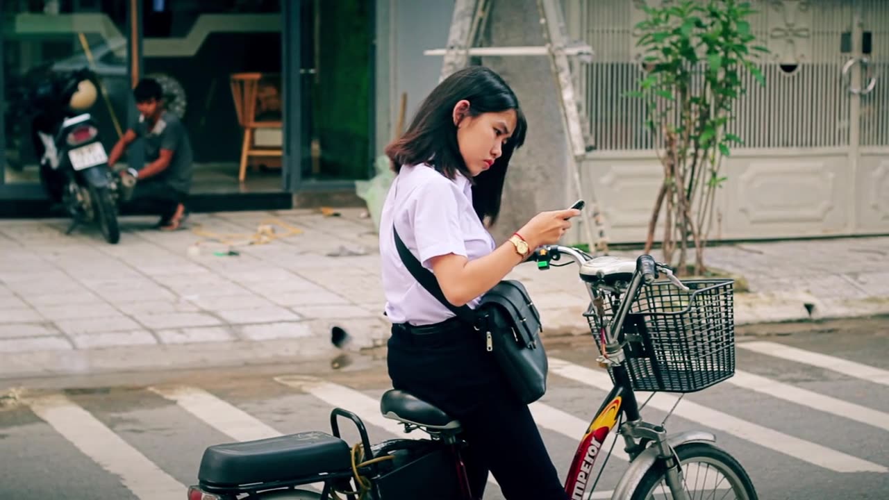 Young Thai girl checking direction on her electric bike