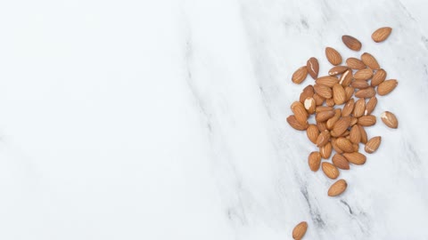 Placing A Hands Full Of Almond Nuts Over The Marble Surface