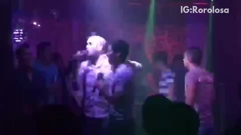 Two guys singing karaoke drunk dance and fall