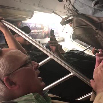 Old guy green shirt glasses singing clapping hands train subway