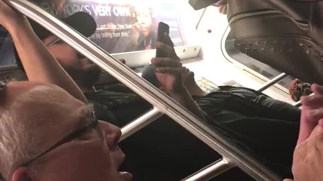 Old guy green shirt glasses singing clapping hands train subway