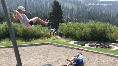 Boy in blue jumps off swing falls off