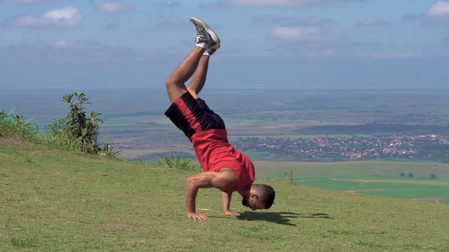 Man Doing Handstand in Grass Field