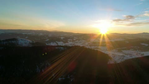 Flying over the mountains into the sunset