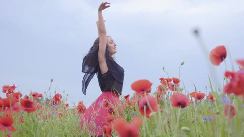 Girl dancing happily in the field of flower