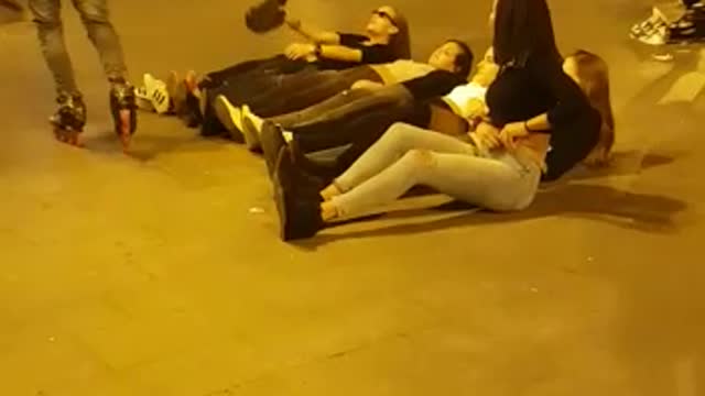 A group of guys jump over girls with a roller