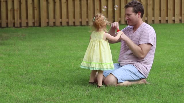 Father and daughter playing with bubbles