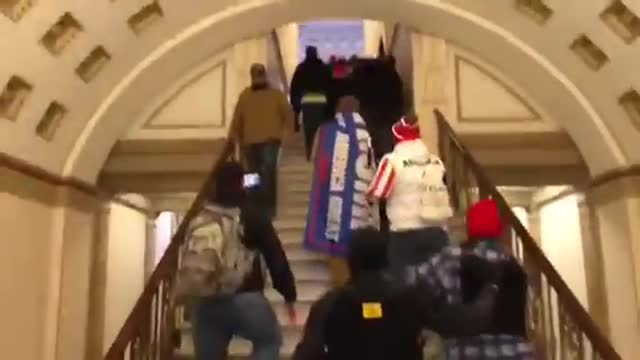 Capitol police open doors for the protestors. They stand aside and invite them inside.