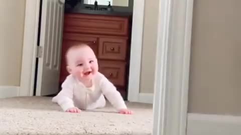 baby laughing at cat