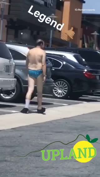 Legend upland man in blue bathing suit in parking lot