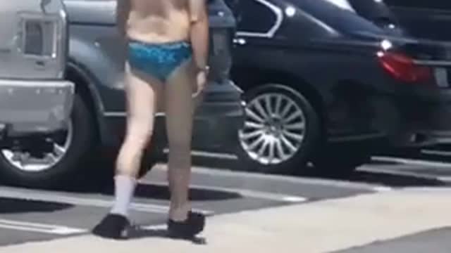 Legend upland man in blue bathing suit in parking lot