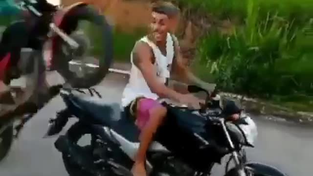 young man pays no attention and ends up hitting his friend with his motorcycle