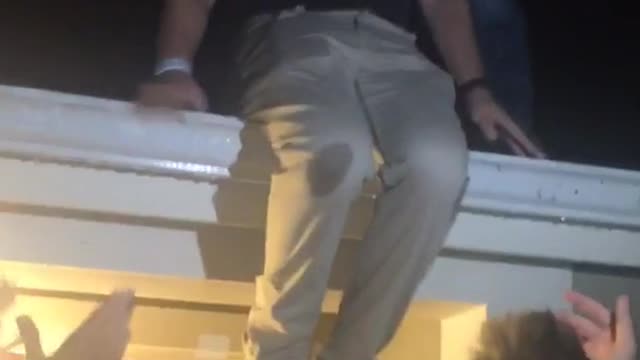 Black tshirt is helped off roof falls into porch